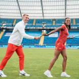 Dos atletas se pasan el testigo simulando el relevo de sedes para el europeo de atletismo
